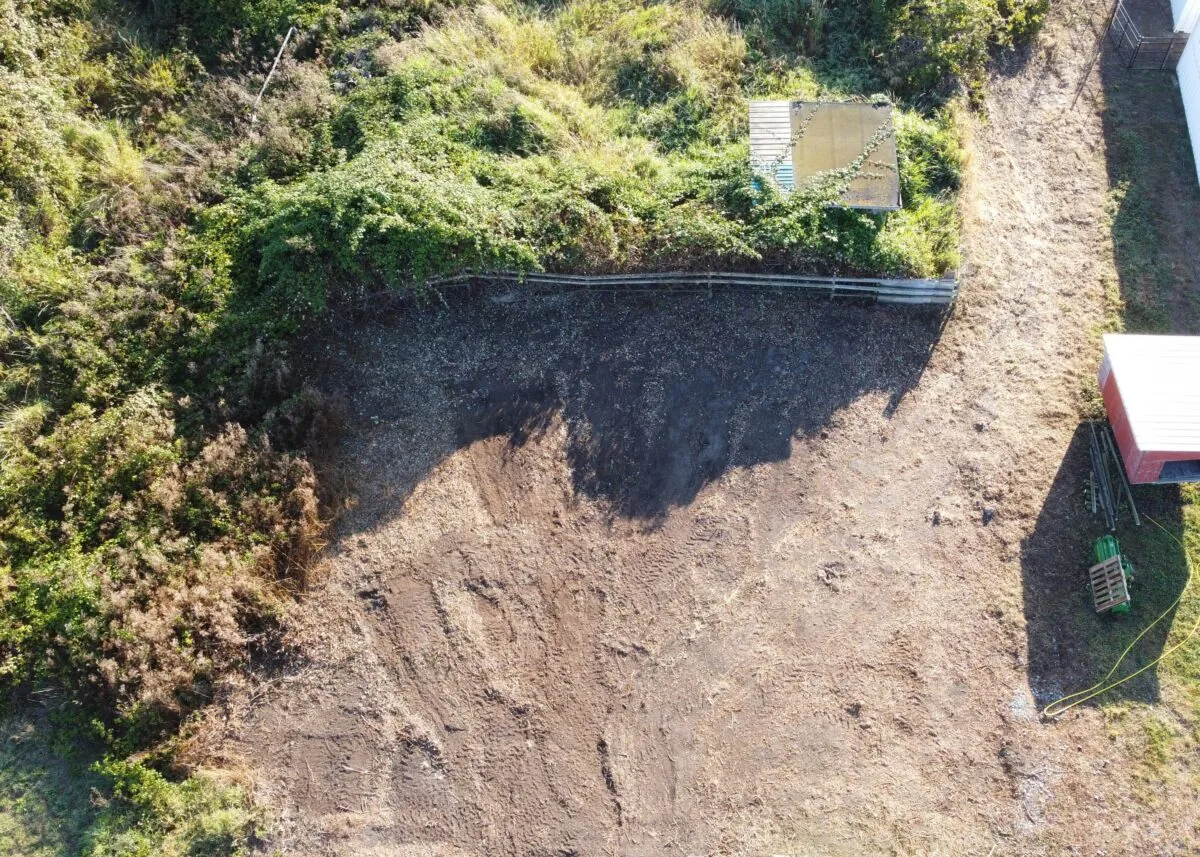 Aerial Agricultural Area Cleared Land Dense Vegetation Small Aerial view of an agricultural area with cleared land, dense vegetation, and a small building.